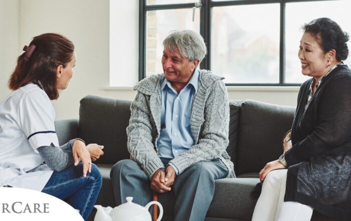 A caregiver talks with an elderly couple representing the kind of communication that professional caregivers need to have to anticipate client needs.