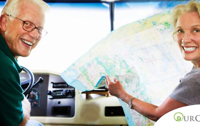 An older couple looks back smiling from the front of an RV, representing how day trips for seniors can help boost the mood of everyone.